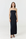 A woman modeling a strapless black maxi dress against a plain white studio background.