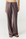 A person wearing wide-leg drawstring pants in a muted taupe-brown color, paired with black sandals, shown against a plain light gray studio background.